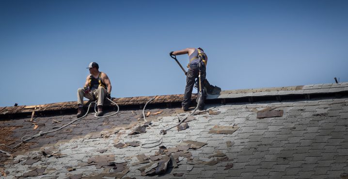Two workers replacing roof