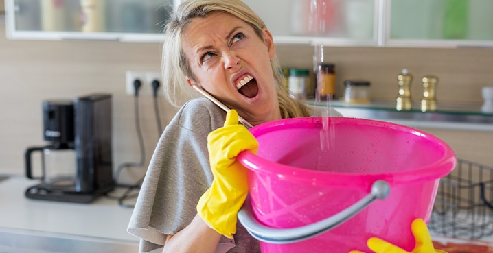 Lady in kitchen with water leak and a bucket roof repair flashing
